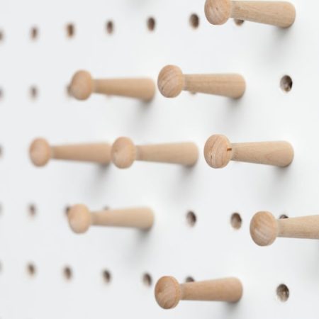 Natural Finish Wood pegs on white pegboard