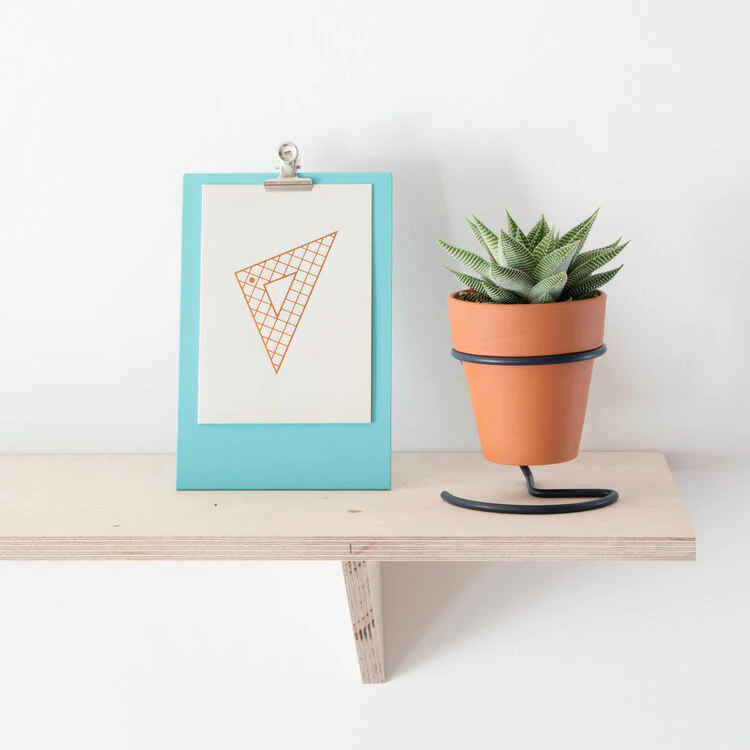 Blue Standing Clipboard Photo Frame, shown on shelf with artwork on display