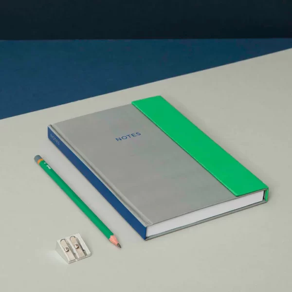 Block Design hardcover notebook on desk next to pencil and sharpener
