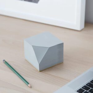 Grey sticky notes block by Block Design, shown on a desk next to a laptop