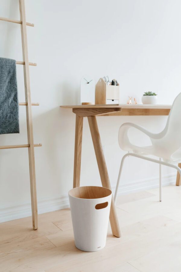White Woodrow trash can shown next to wooden desk