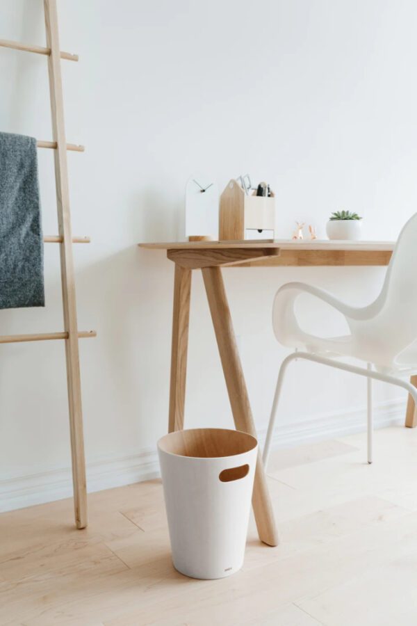 White Woodrow trash can shown next to wooden desk